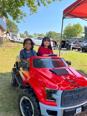 Children enjoying Toro Contracting LLC mini truck at community event - Maryland roof restoration experts